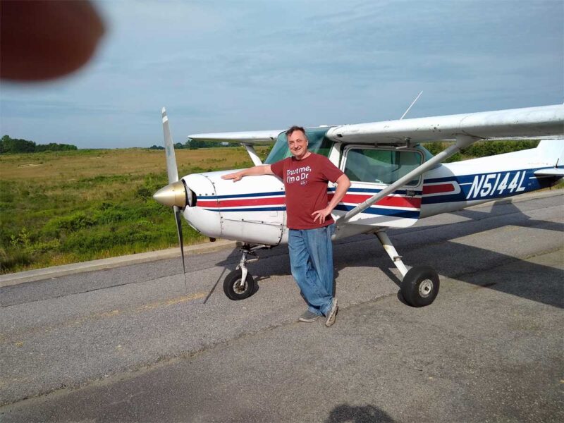 A man standing next to an airplane on the tarmac.