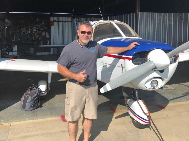 A man standing next to an airplane on the ground.